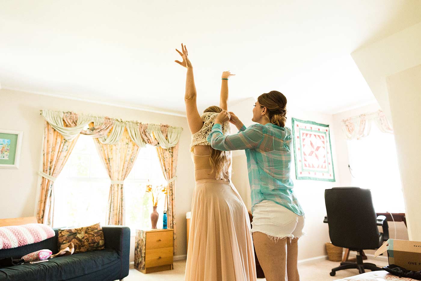 Bride putting on wedding dress