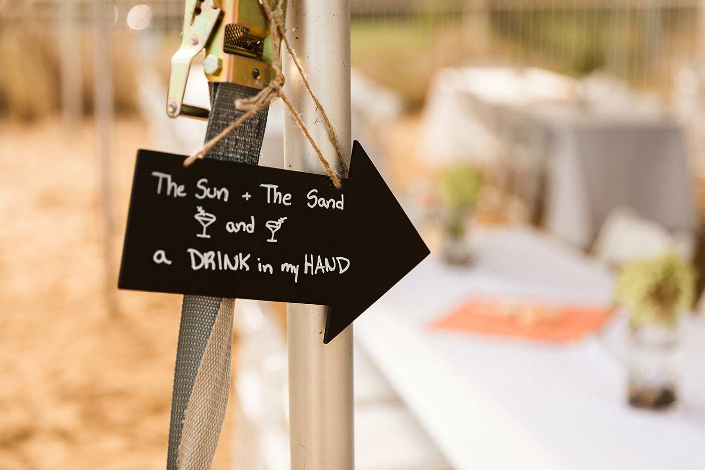 sign reading "The Sun + The Sand and a DRINK in my HAND"