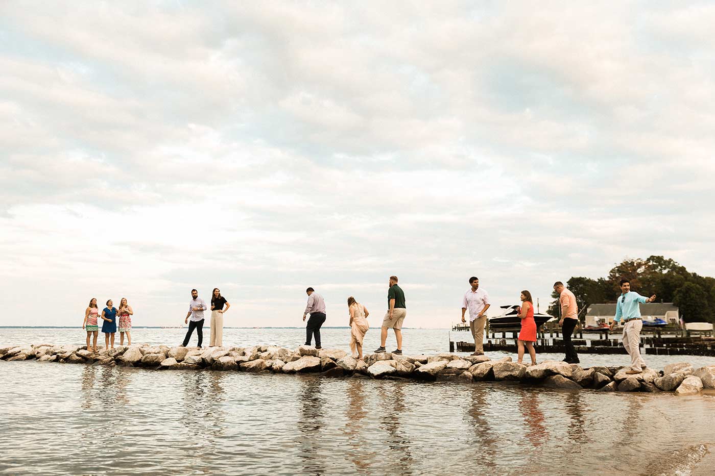 wedding guests standing on rocks over water