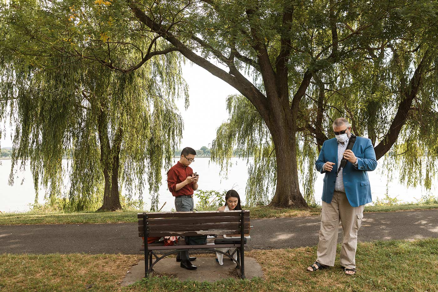 Woman and two men standing in park along potomac river