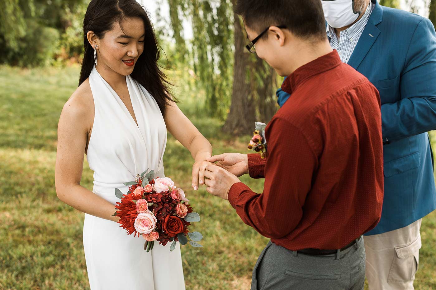 Groom putting ring on bride's finger