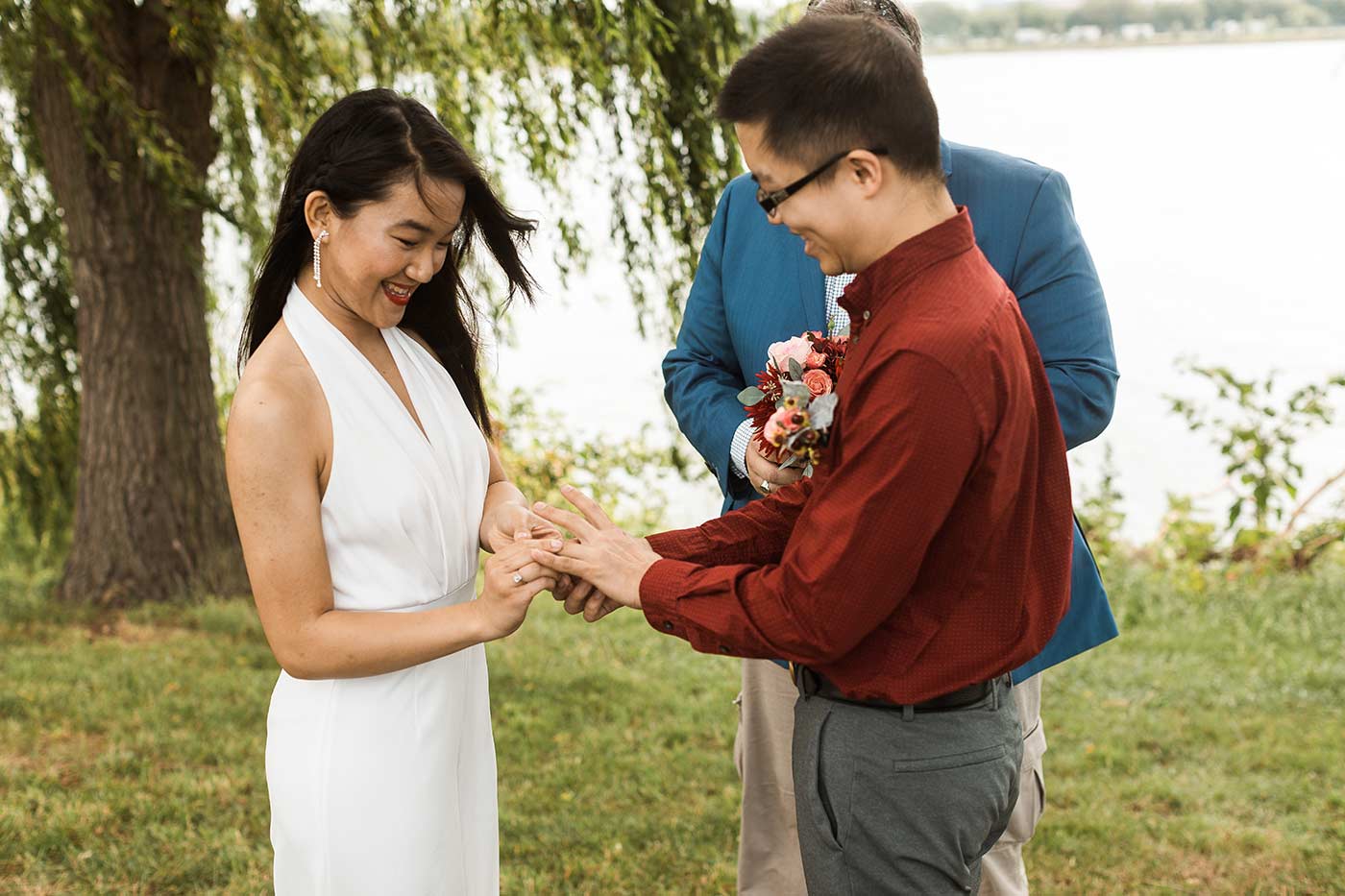 bride putting ring on groom's finger