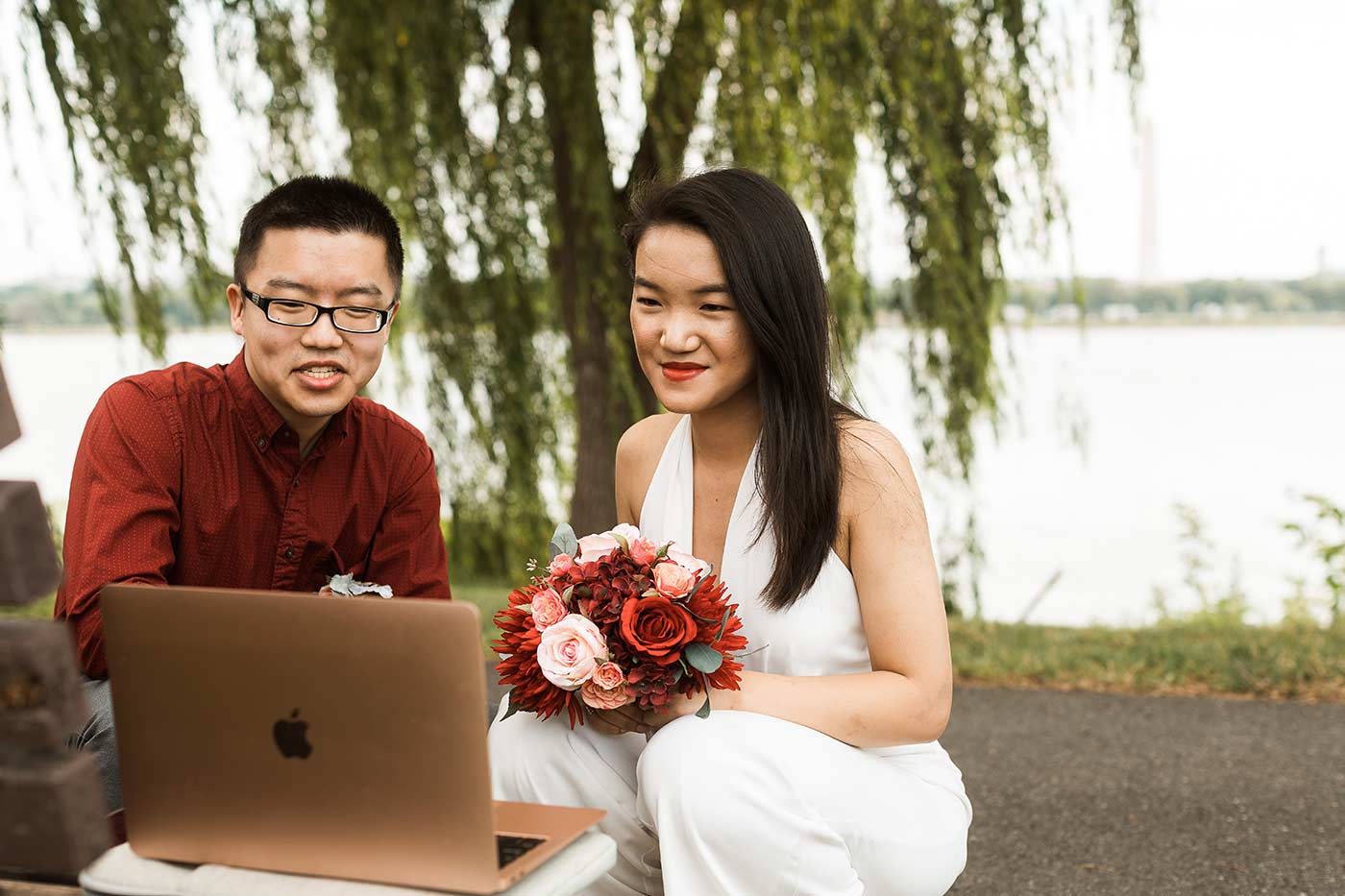 Bride and groom talking to family through laptop