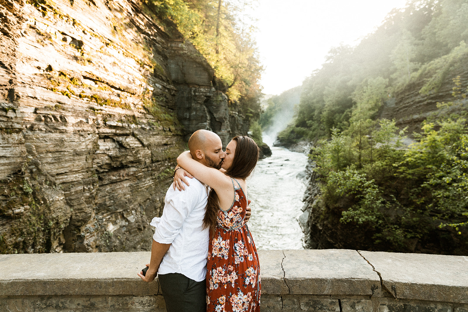 man kissing woman with ring hidden behind his back