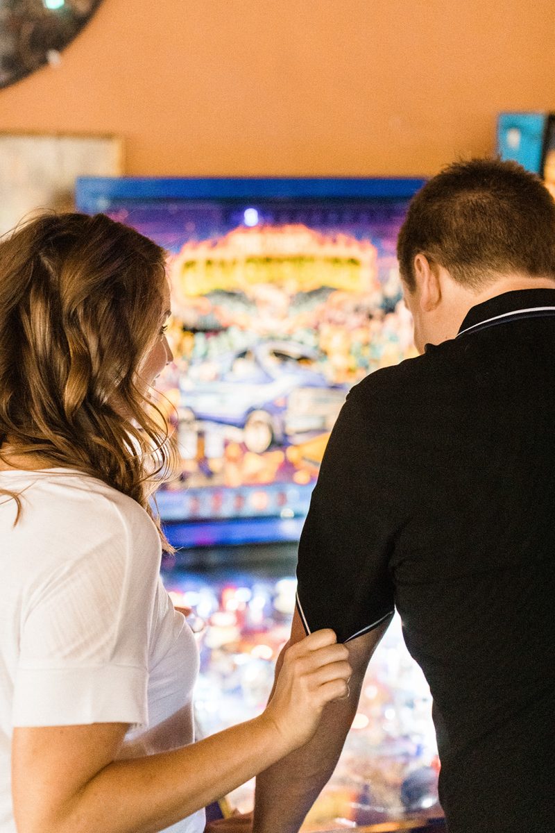 woman and man playing pinball