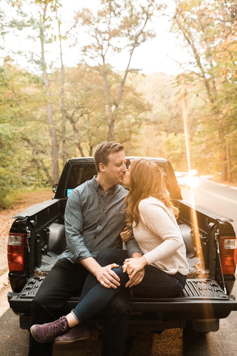 couple kissing in bed of pickup truck