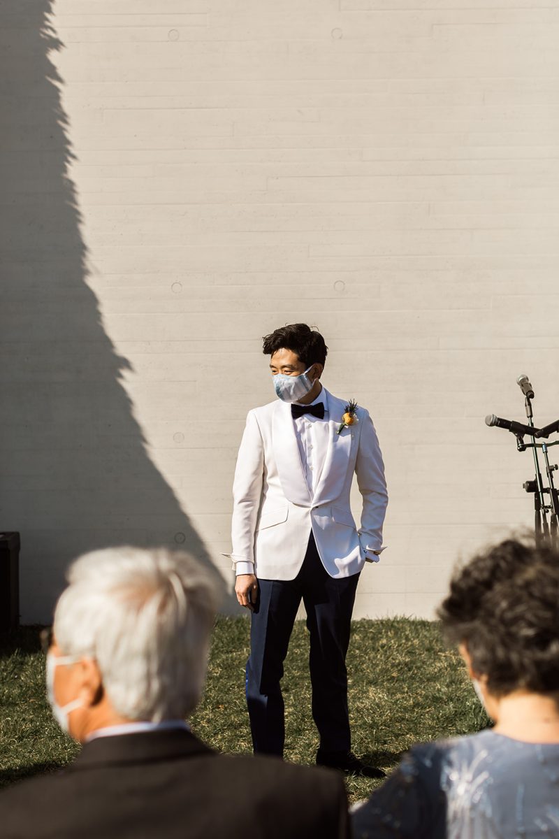 groom in white tuxedo covid wedding