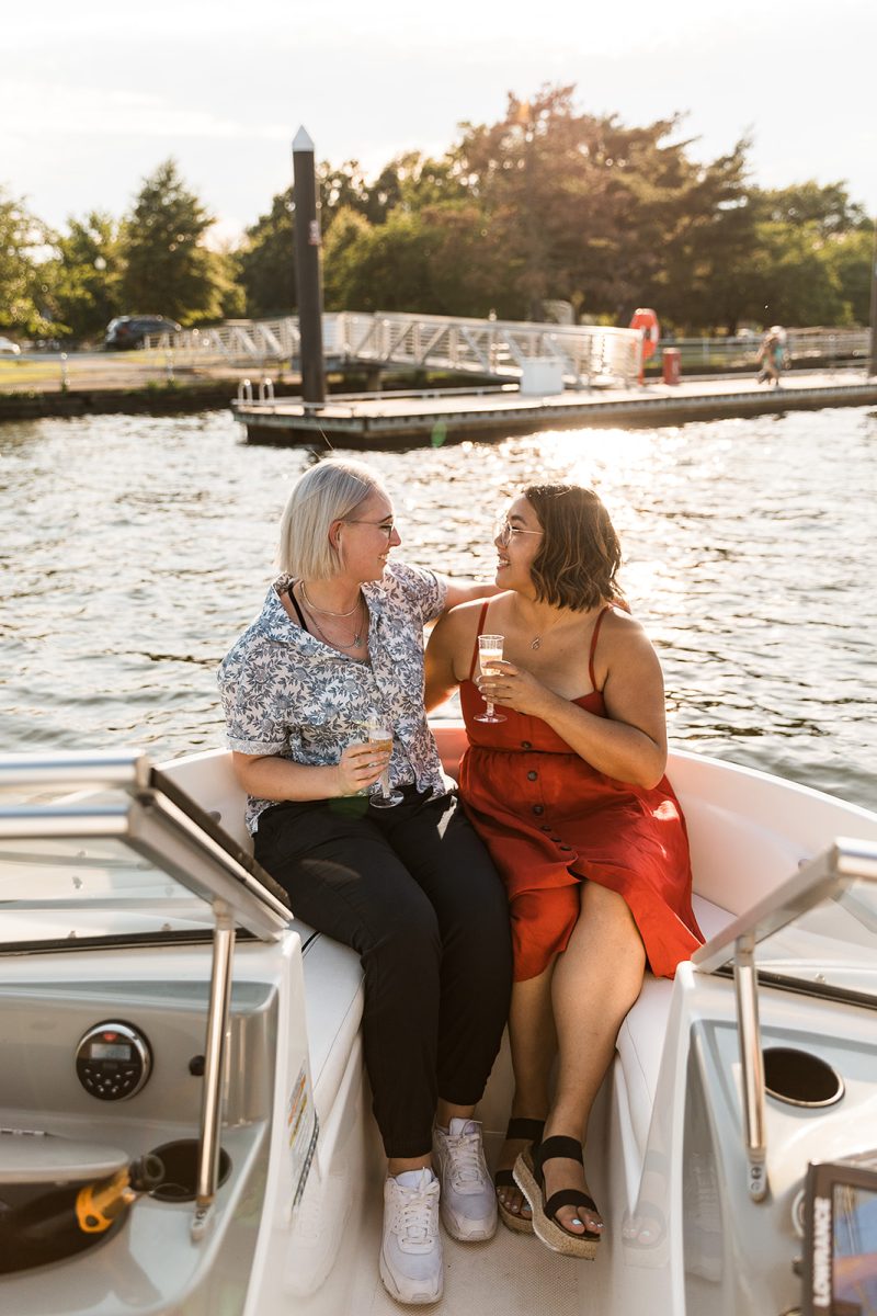 women on a boat embracing and drinking champagne