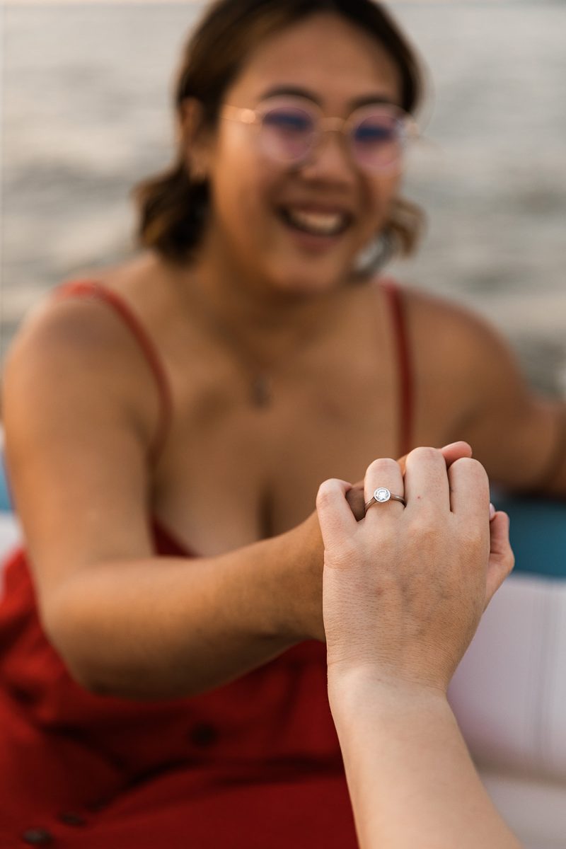 woman holding her partners hand showing engagement ring