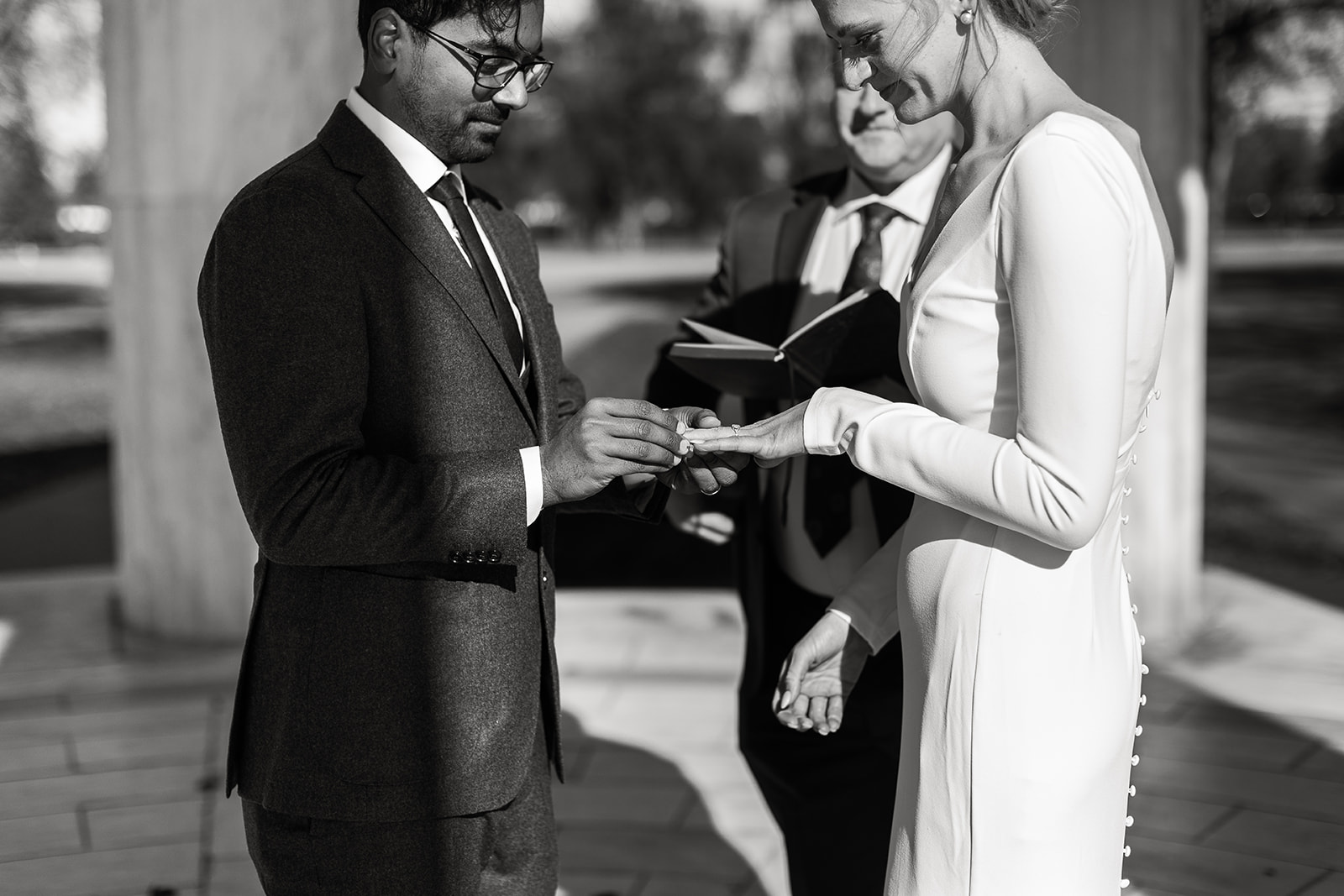 groom putting ring on bride's finger