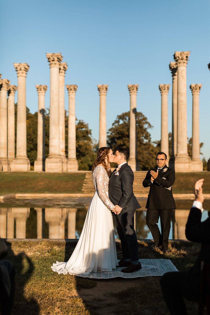 Couple having first kiss as Mrs & Mrs during wedding ceremony at National Arboretum in Washington DC. 