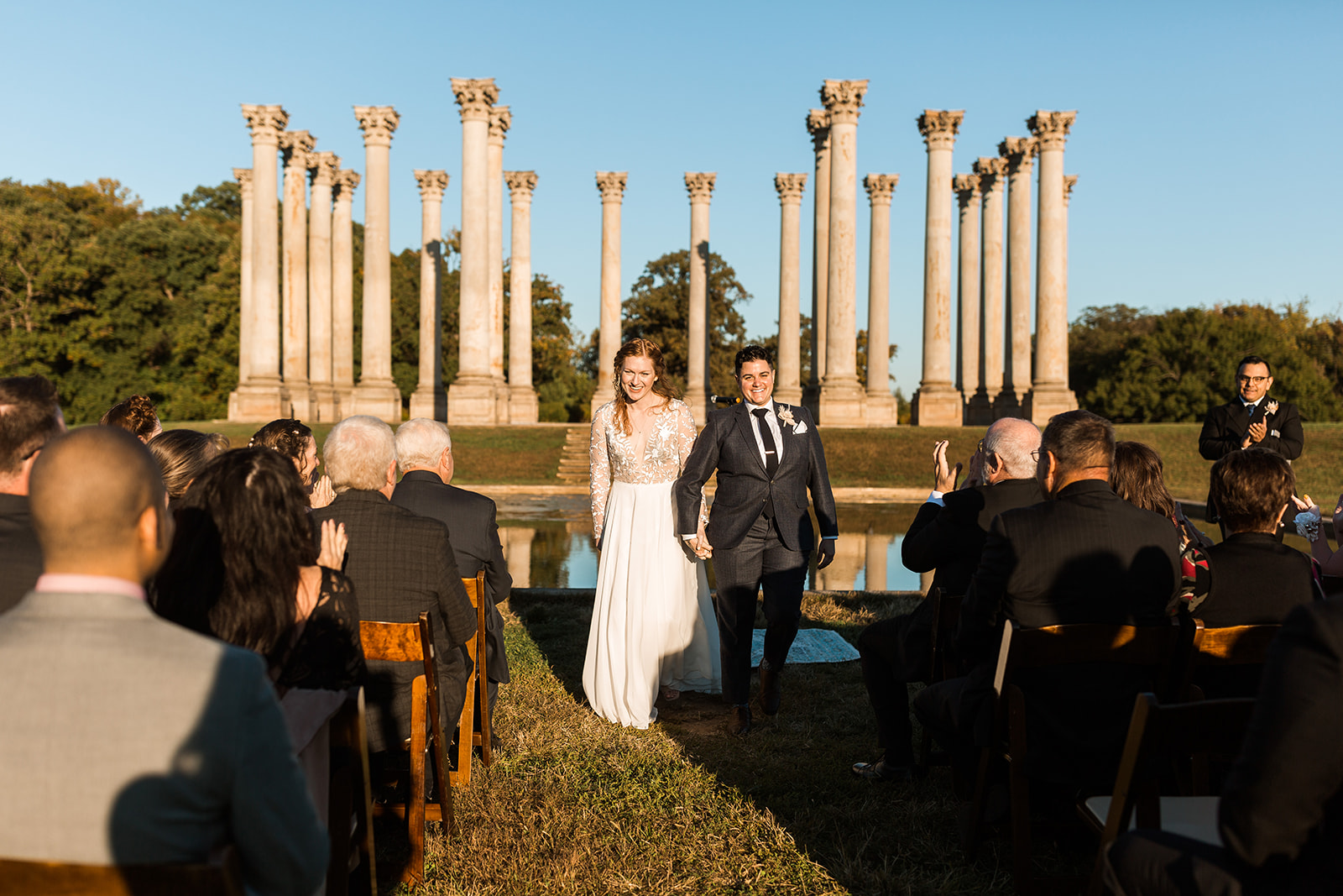 LGBTQ+ couple recessign down aisle after wedding ceremony at National Arboretum. 