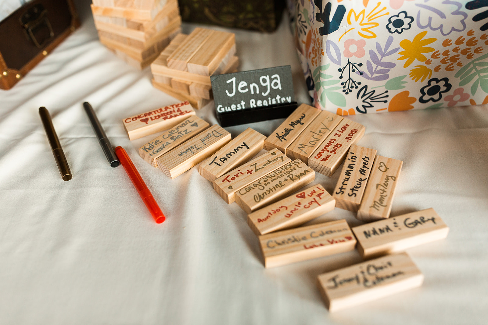 Jenga pieces with names handwritten on them, next to sign that reads 'Jenga Guest Registry'. 