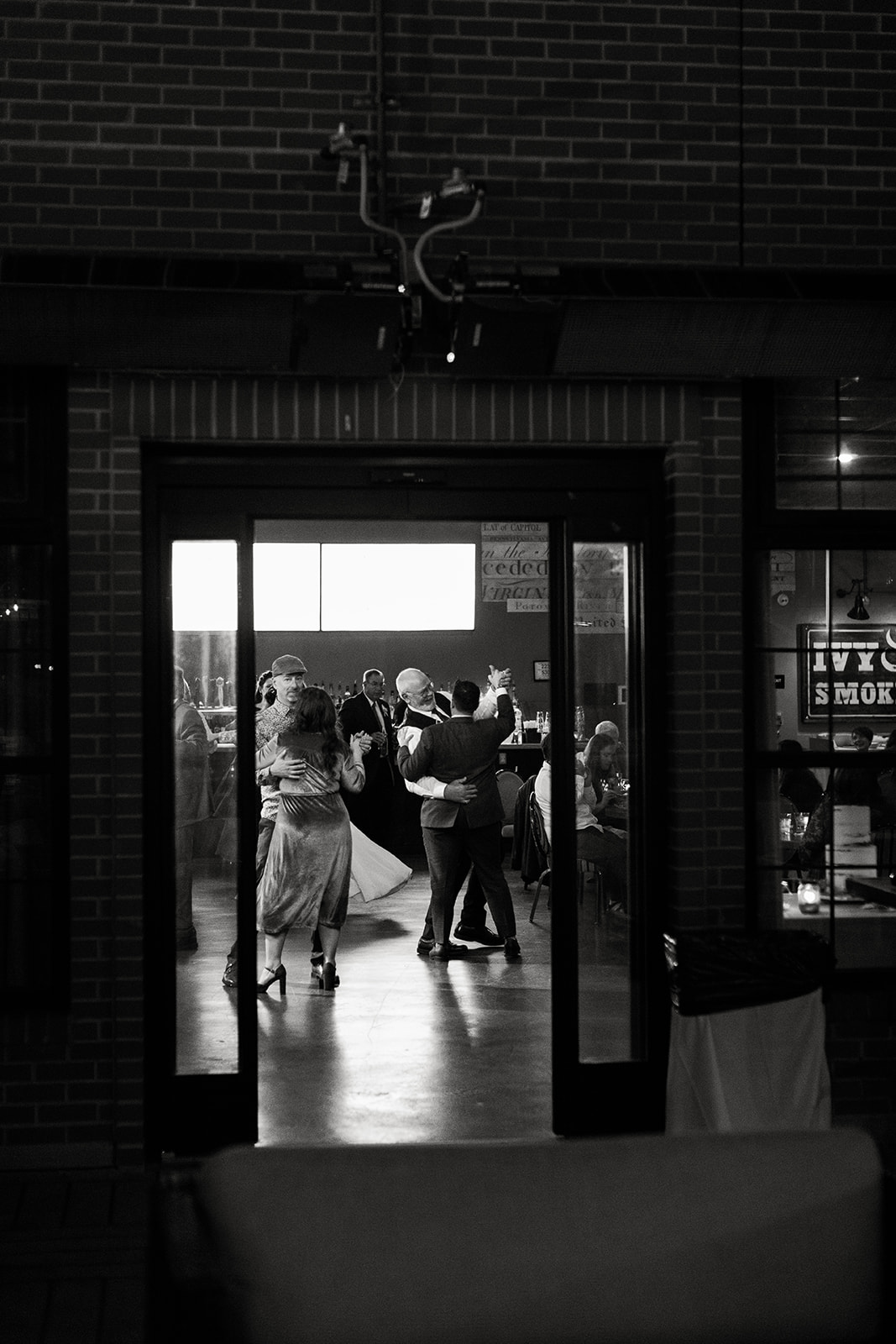 View from outside of Ivy City Smokehouse looking in to guests dancing. 