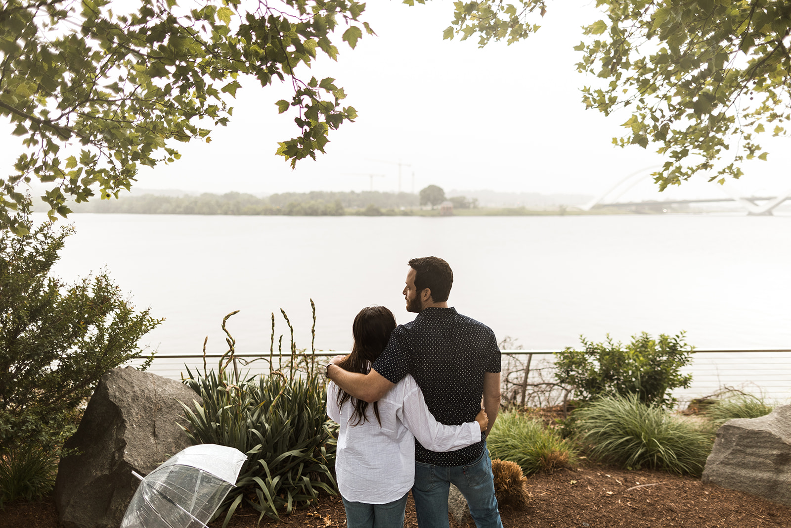 man and woman facing away from camera in front of potomac river