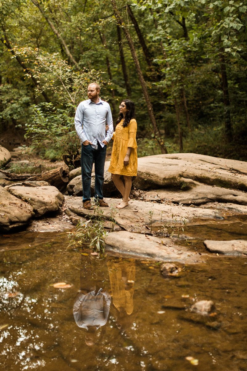 couple standing on rocks in the james river near richmond virginia