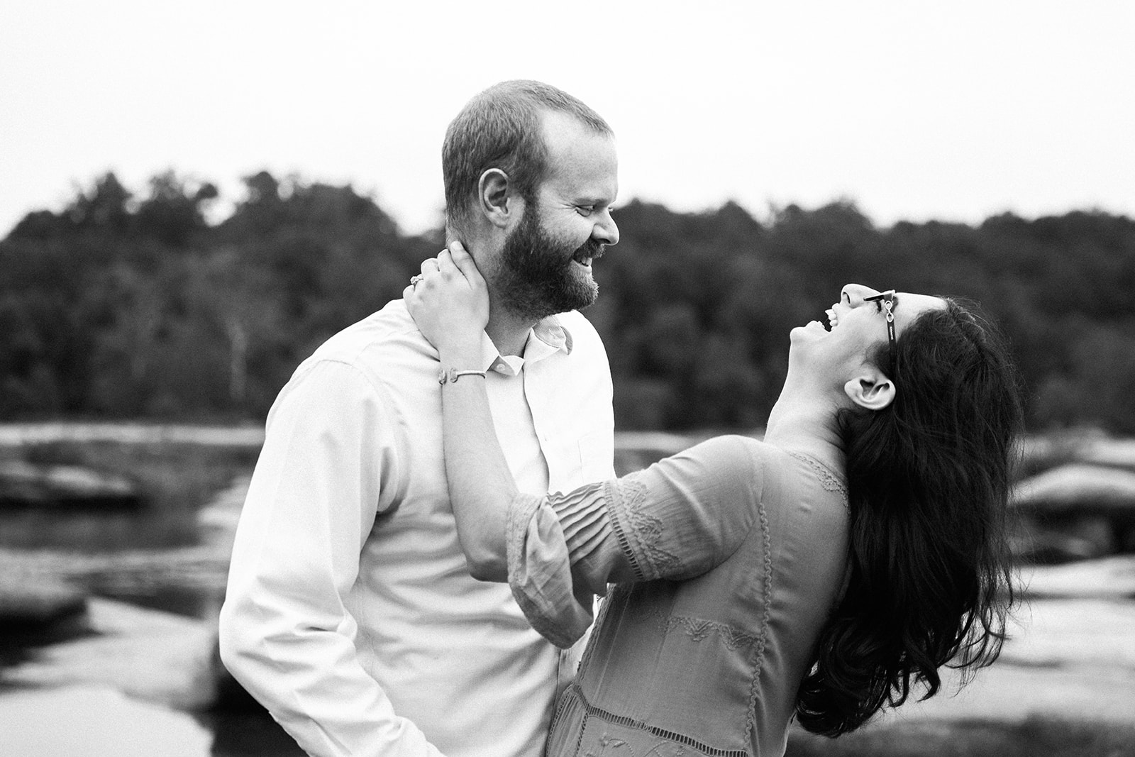 couple laughing and standing in the james river near richmond virginia