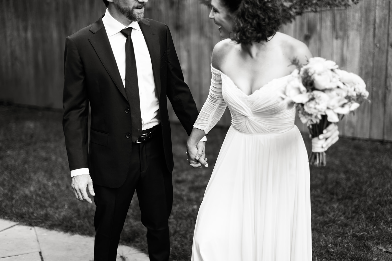 Bride and groom holding hands and talking 