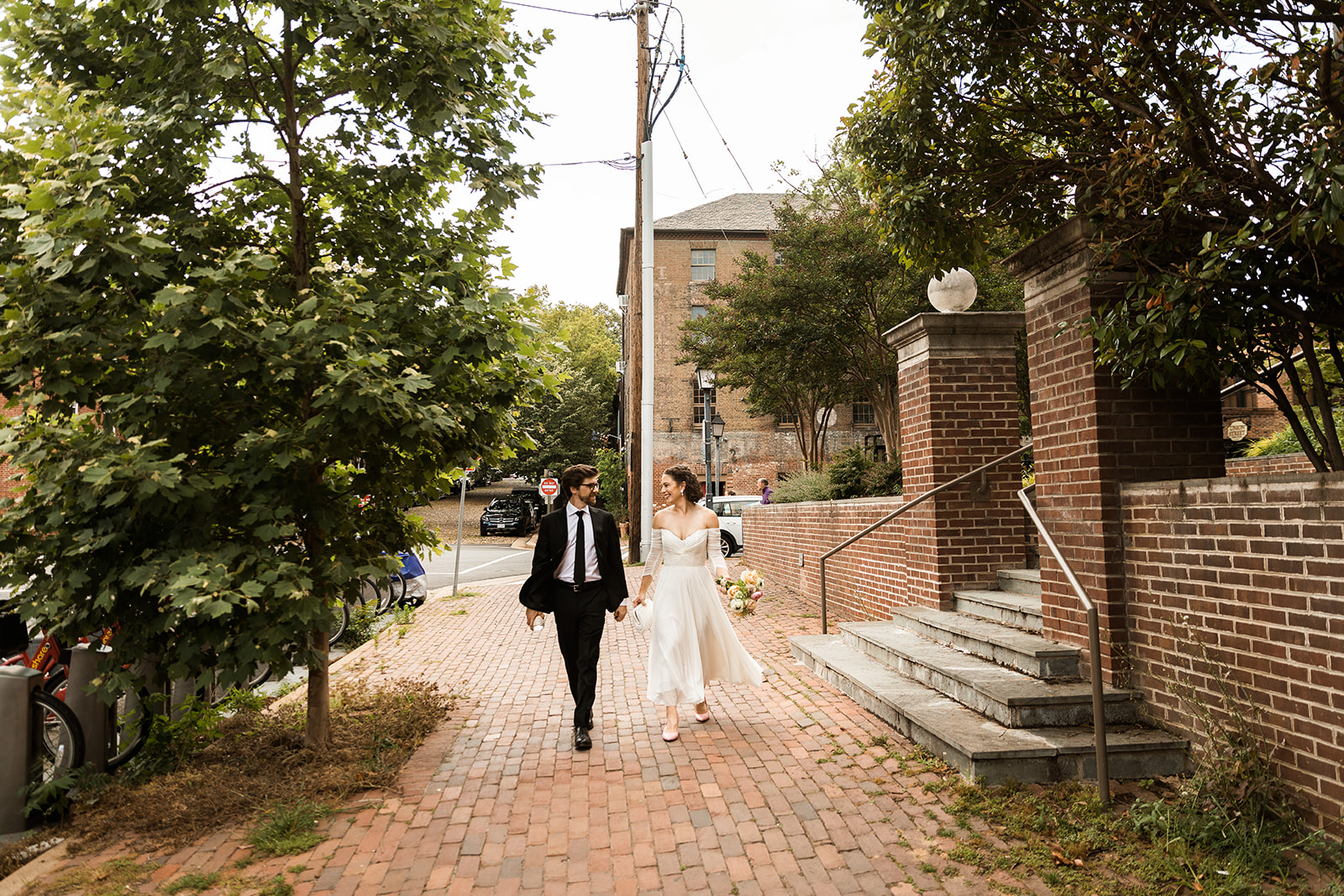 bride and groom walking down brick sidewalk in old town alexandria 