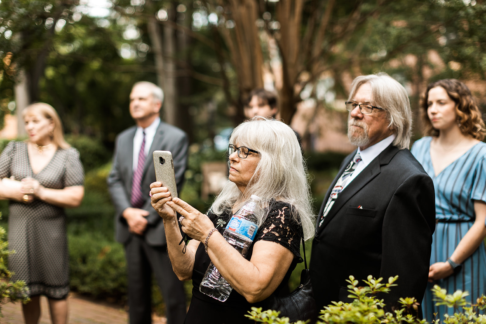 guests and family members watching a wedding ceremony in the garden at carlyle house