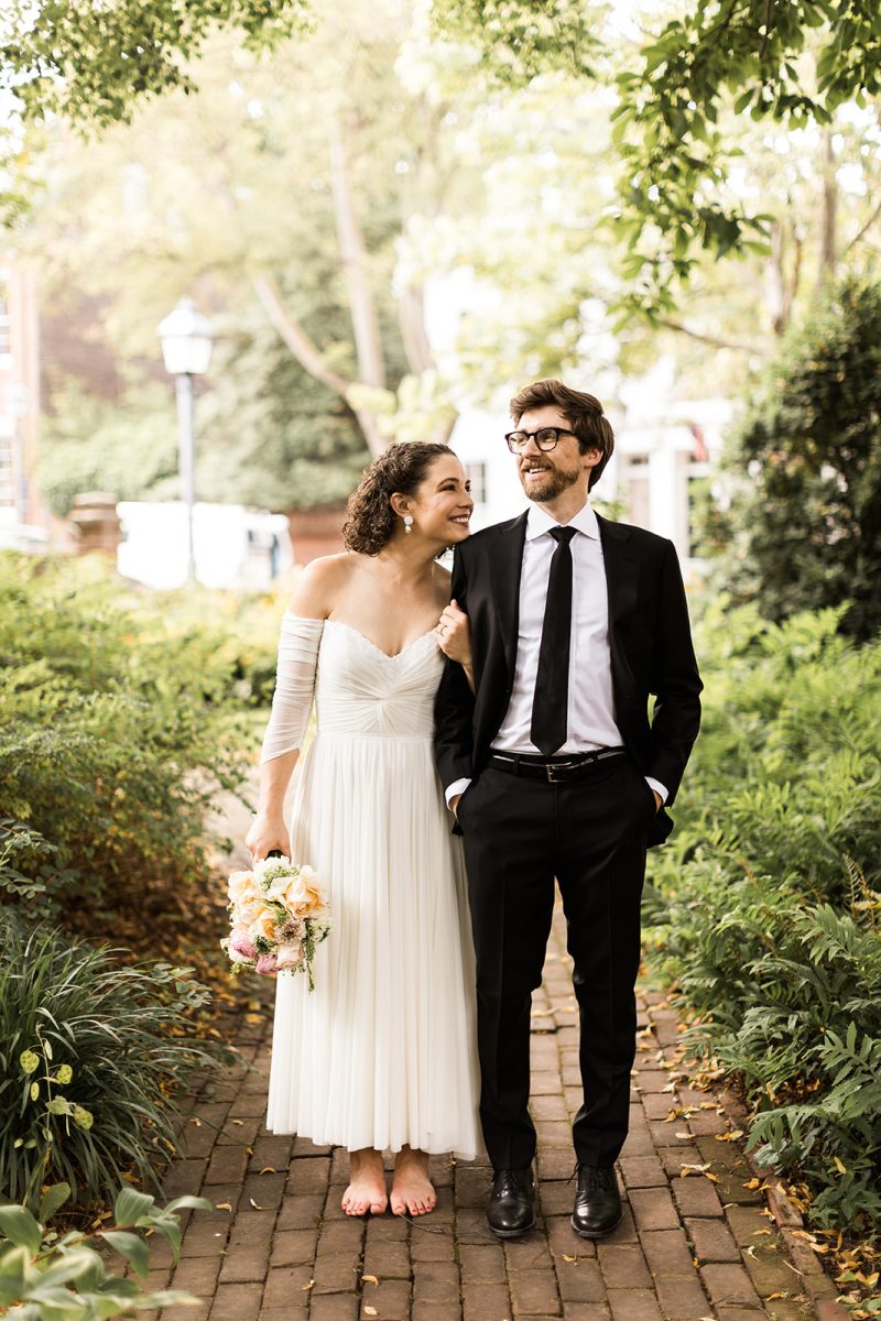 bride walking barefoot and smiling at groom in garden at carlyle house