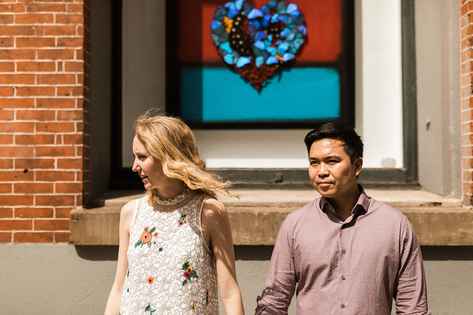 man and woman posing in front of colorful window in NYC