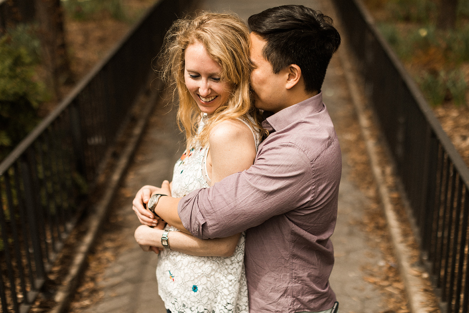 man hugging woman from behind in park