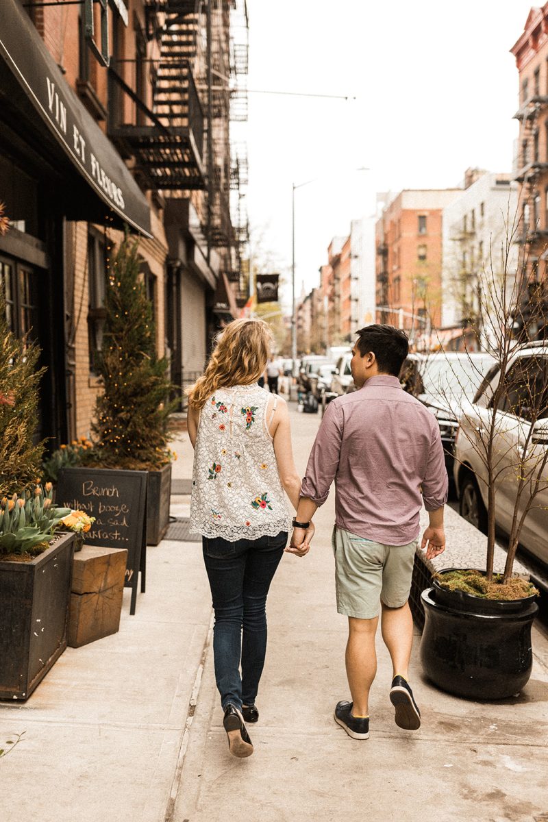 man and woman walking down street in soho holding hands
