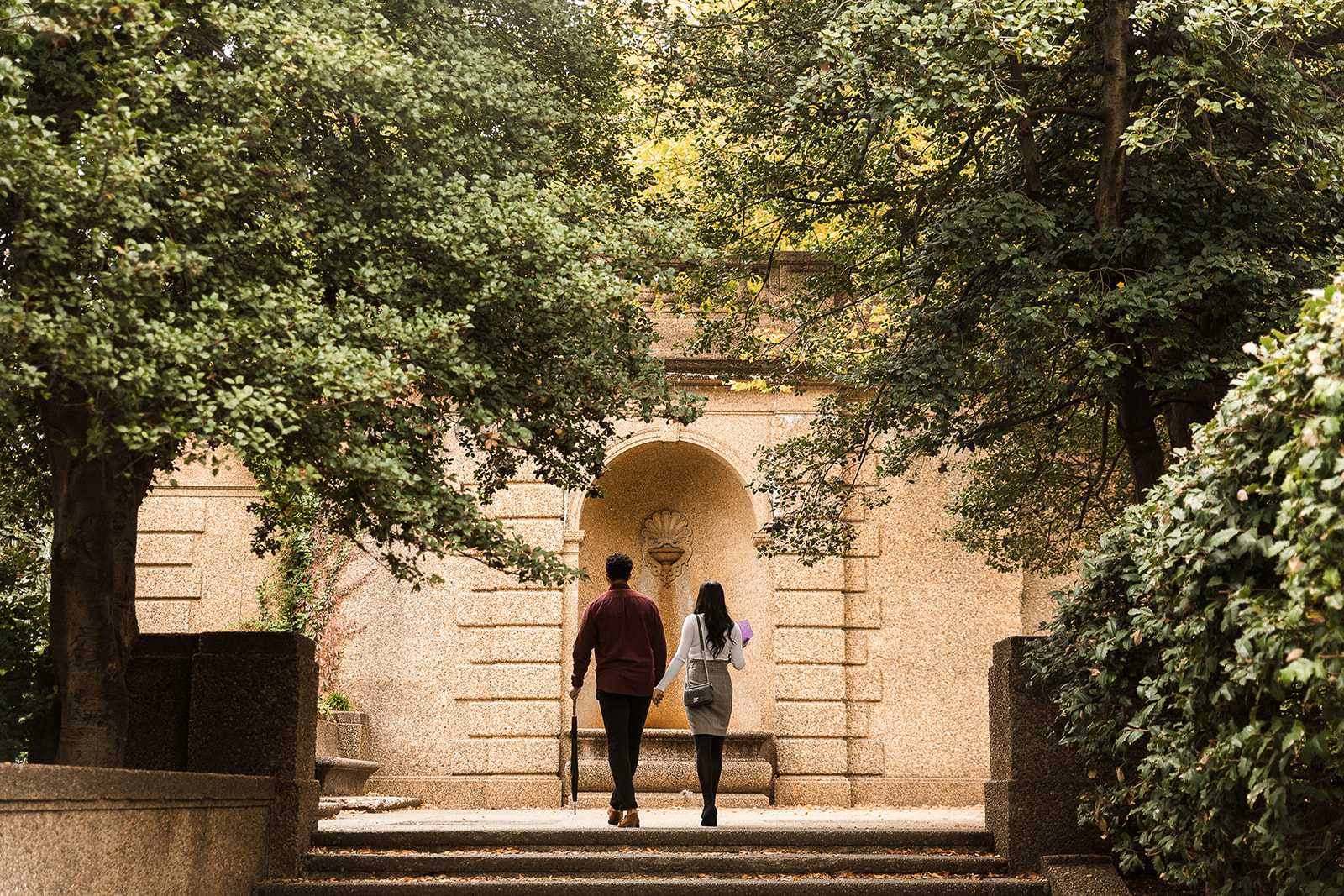 couple holding hands walking through meridian hill park in washington dc
