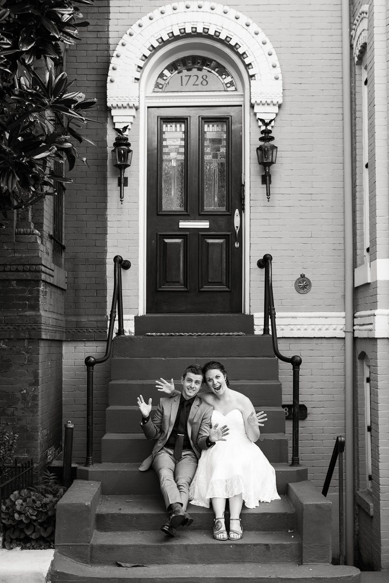 bride and groom making funny faces on front steps of house 