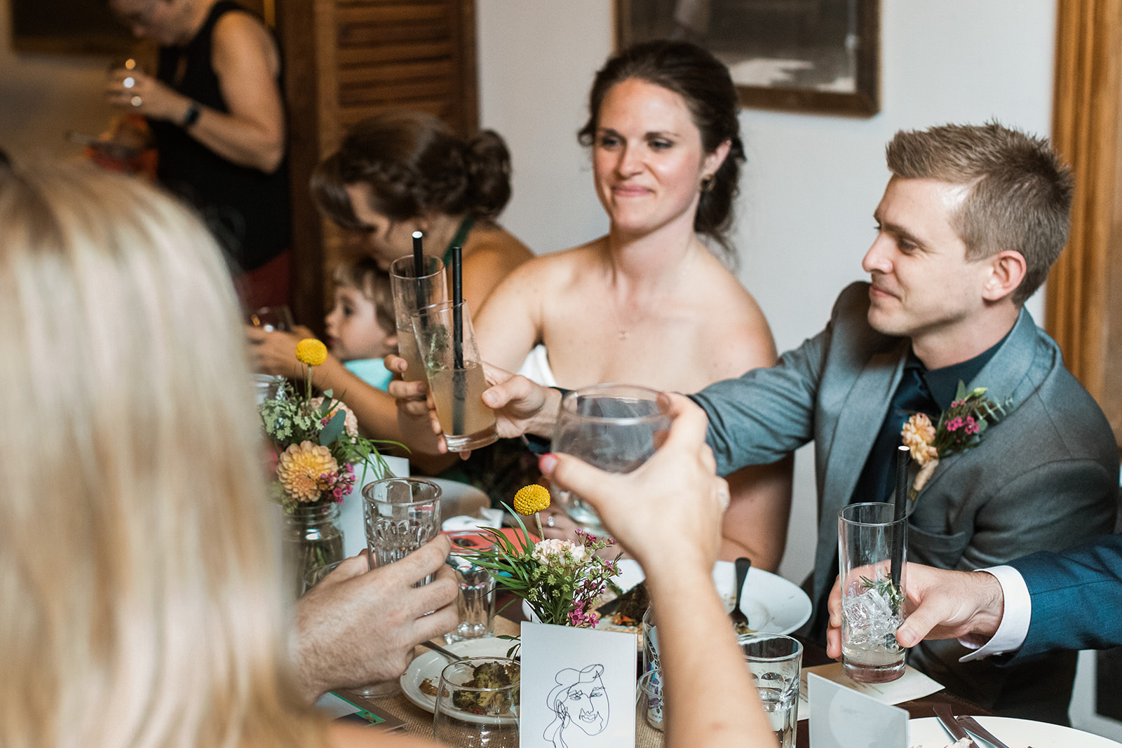 bride and groom raising glasses for toast at wedding 