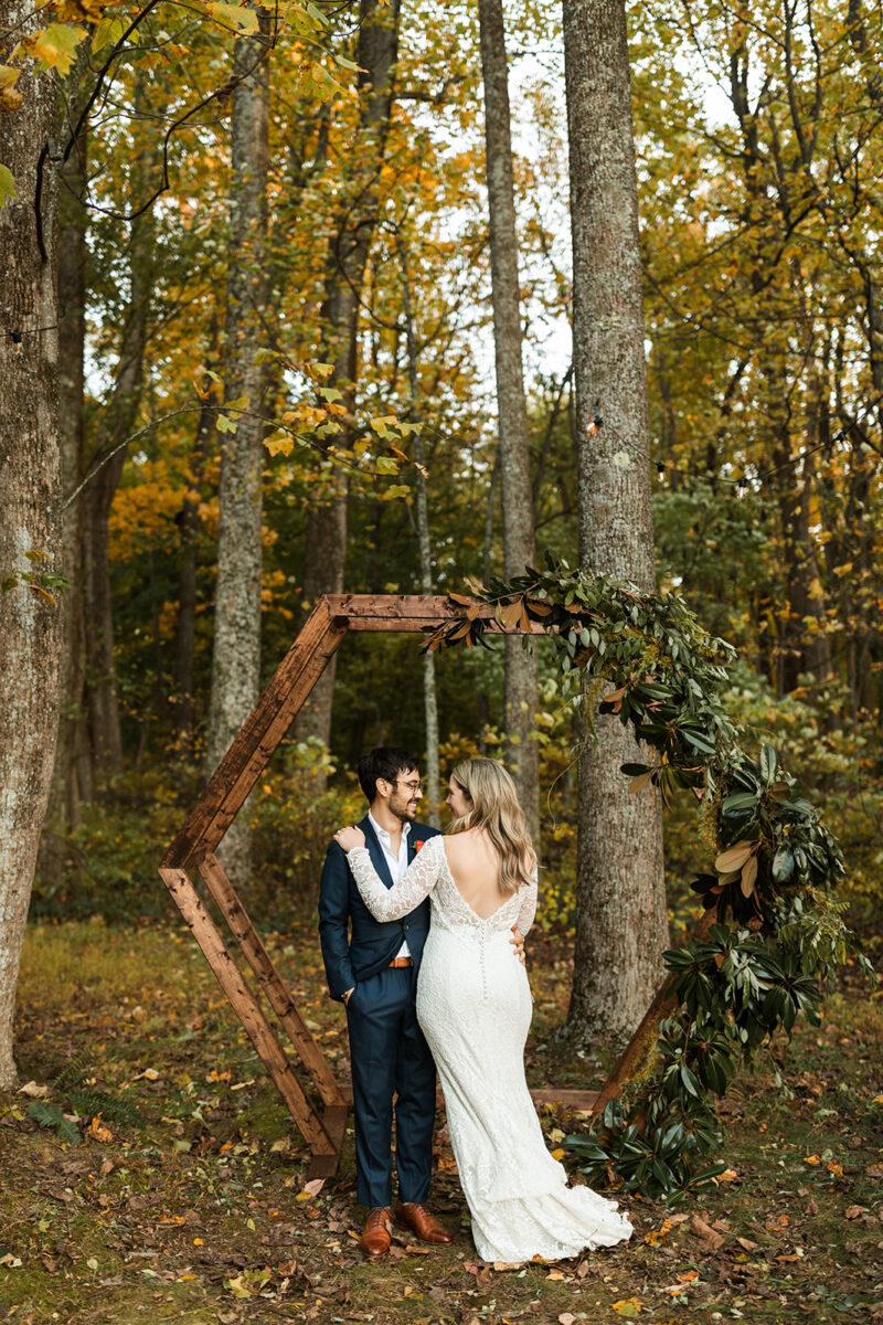 bride and groom portraits in front of their ceremony arch