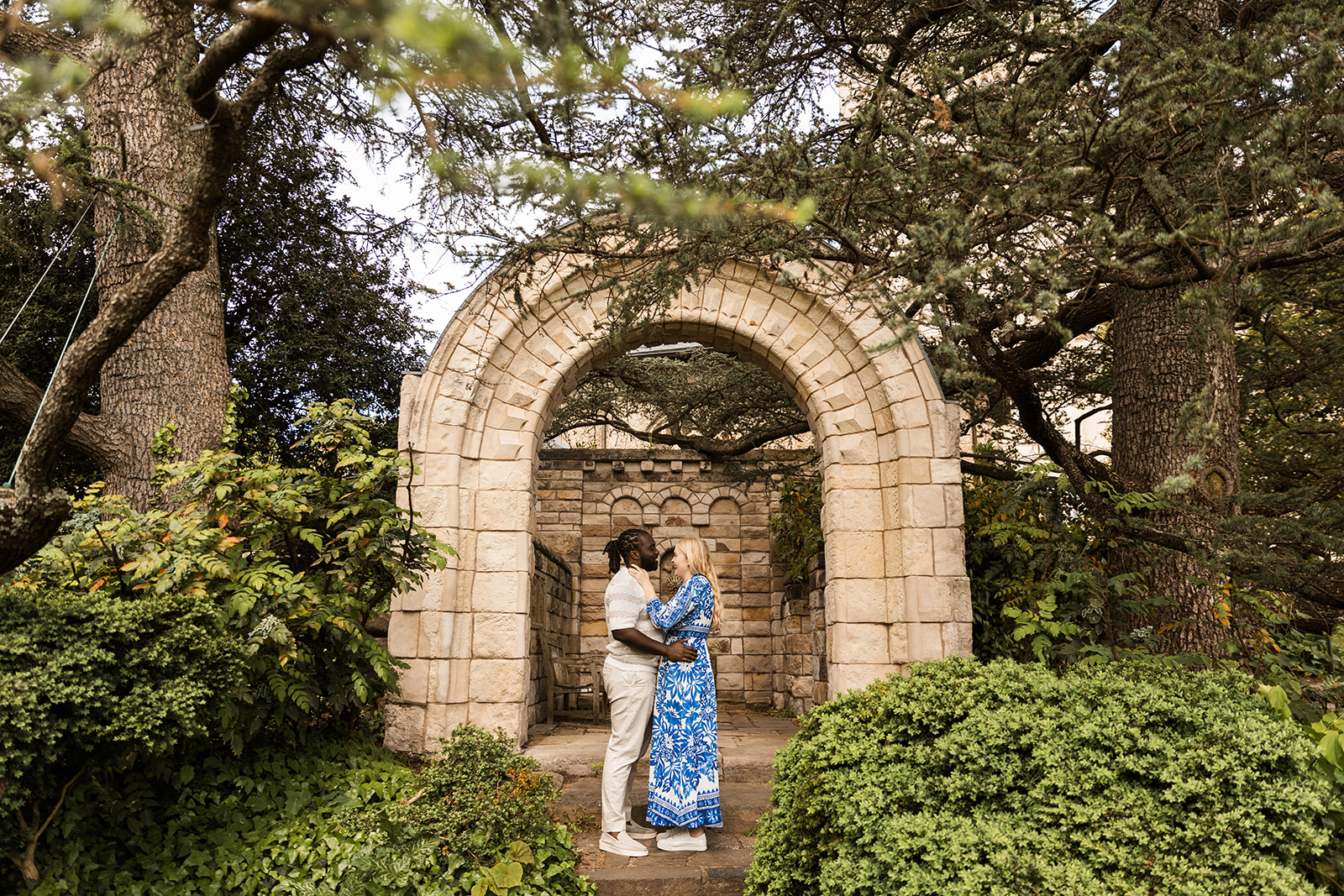 sweet and playful couple roaming the gardens for their engagement photos at the national cathedral in dc