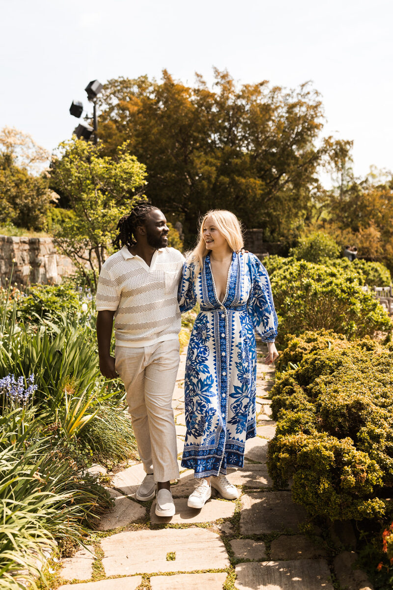 sweet and playful couple roaming the gardens for their engagement photos at the national cathedral in dc
