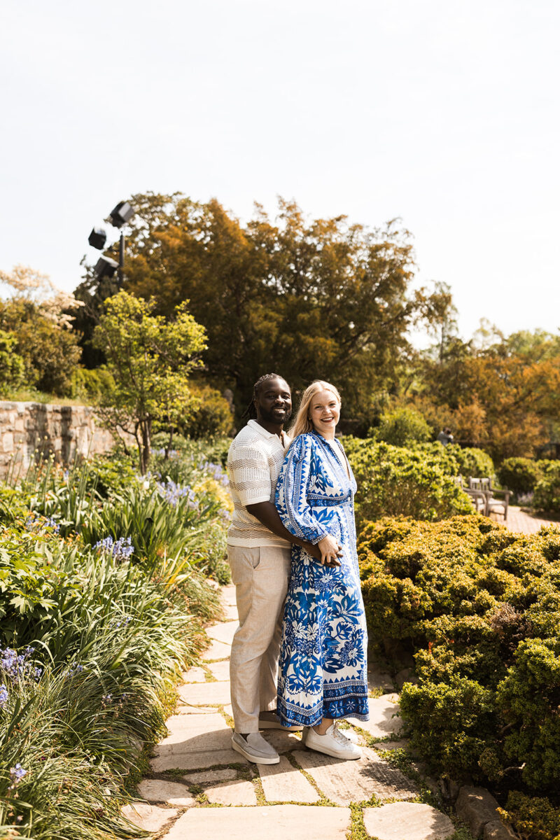 sweet and playful couple roaming the gardens for their engagement photos at the national cathedral in dc
