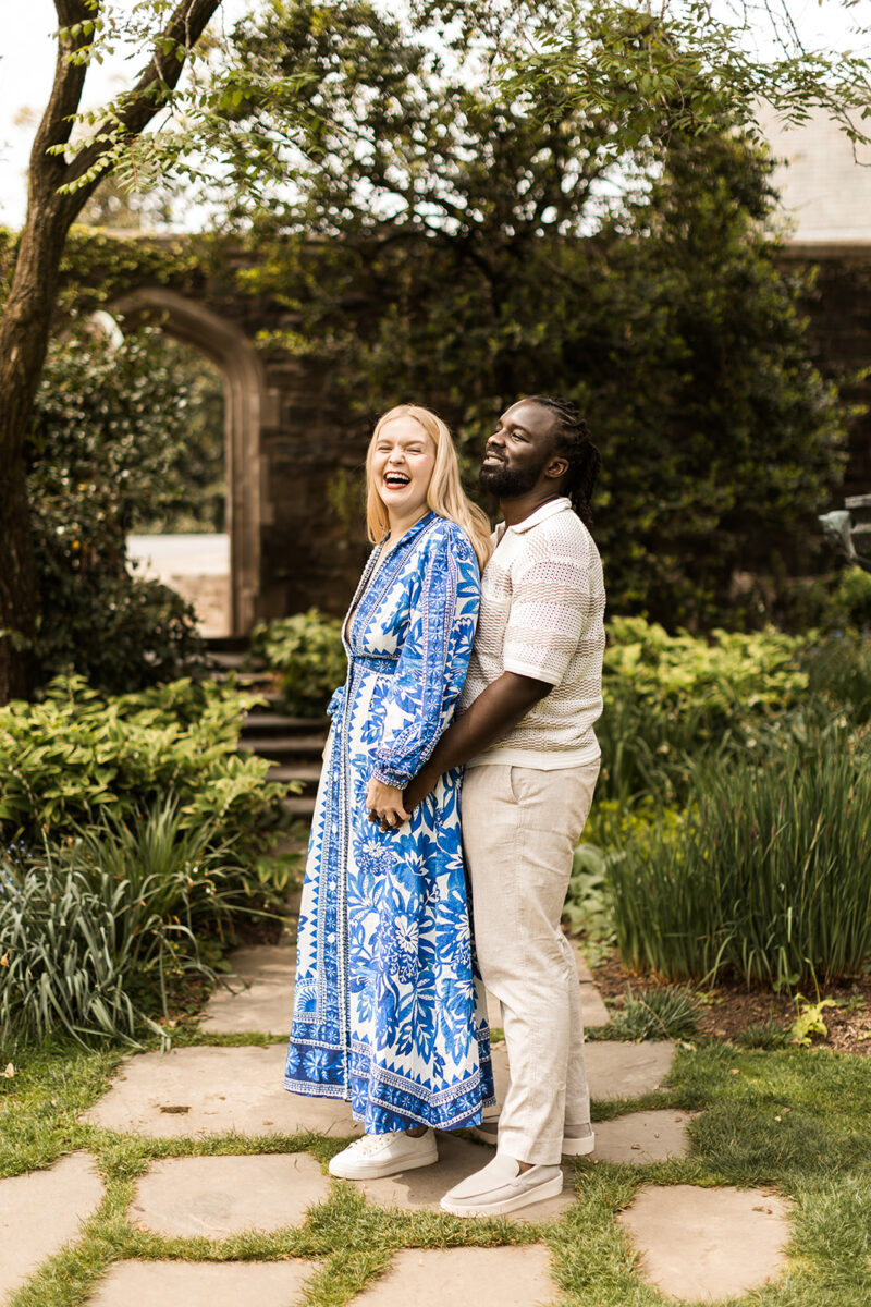 sweet and playful couple roaming the gardens for their engagement photos at the national cathedral in dc