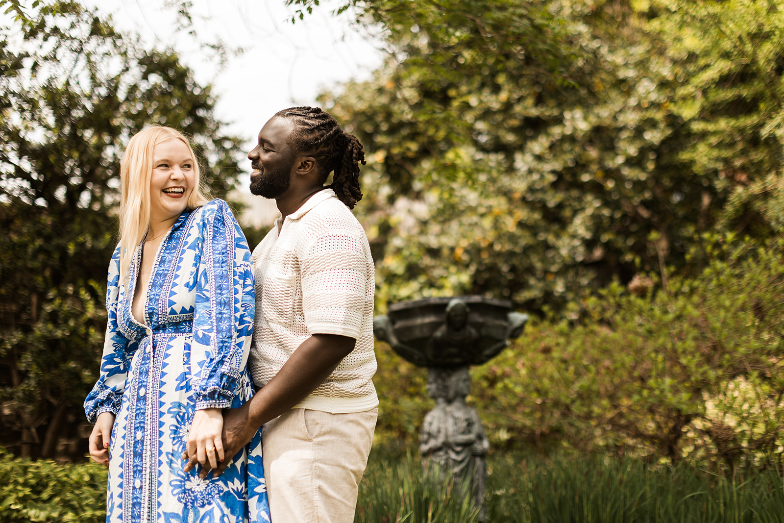 sweet and playful couple roaming the gardens for their engagement photos at the national cathedral in dc