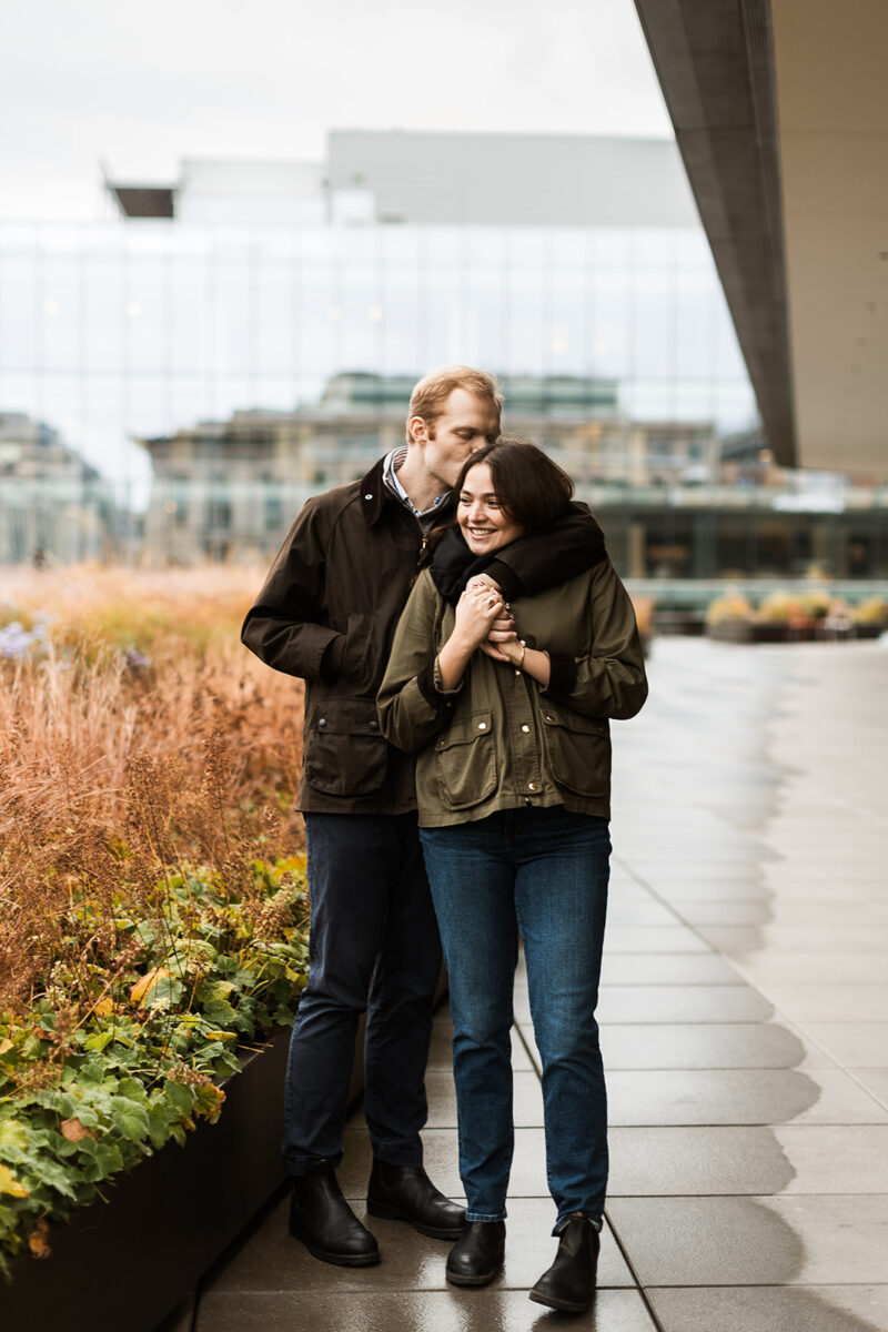 sweet couple snuggling on a rainy rooftop in dc