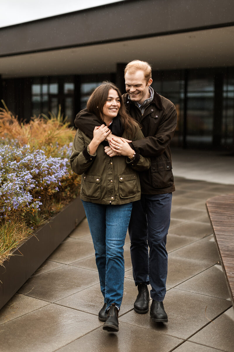 sweet couple snuggling on a rainy rooftop in dc