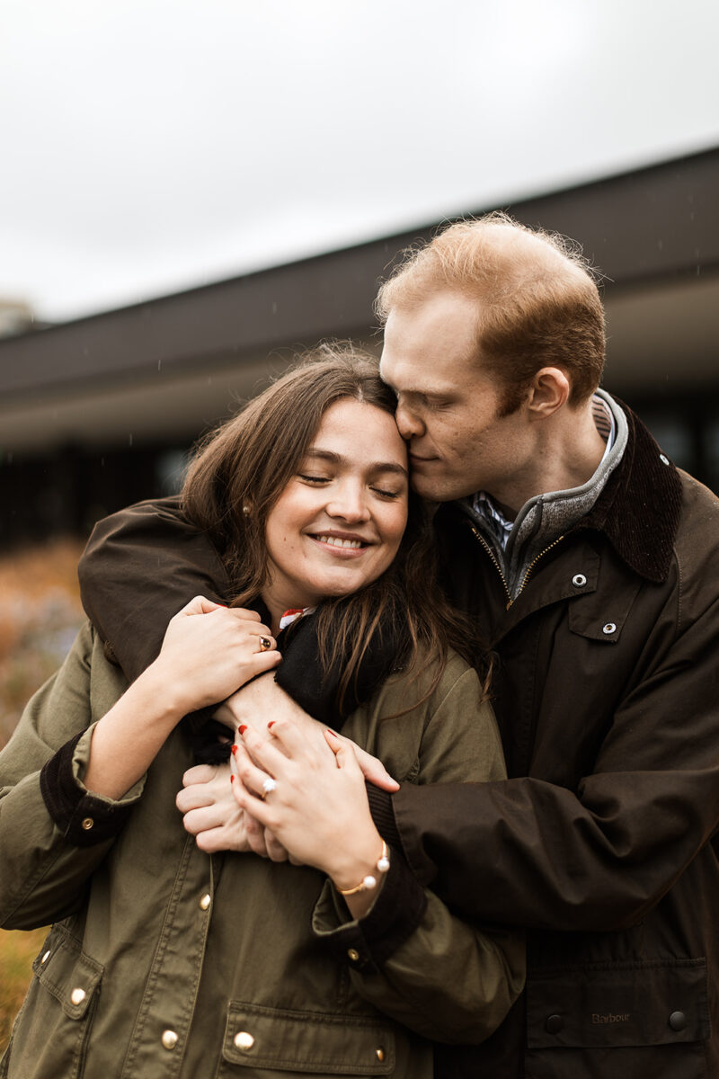 sweet couple snuggling on a rainy rooftop in dc